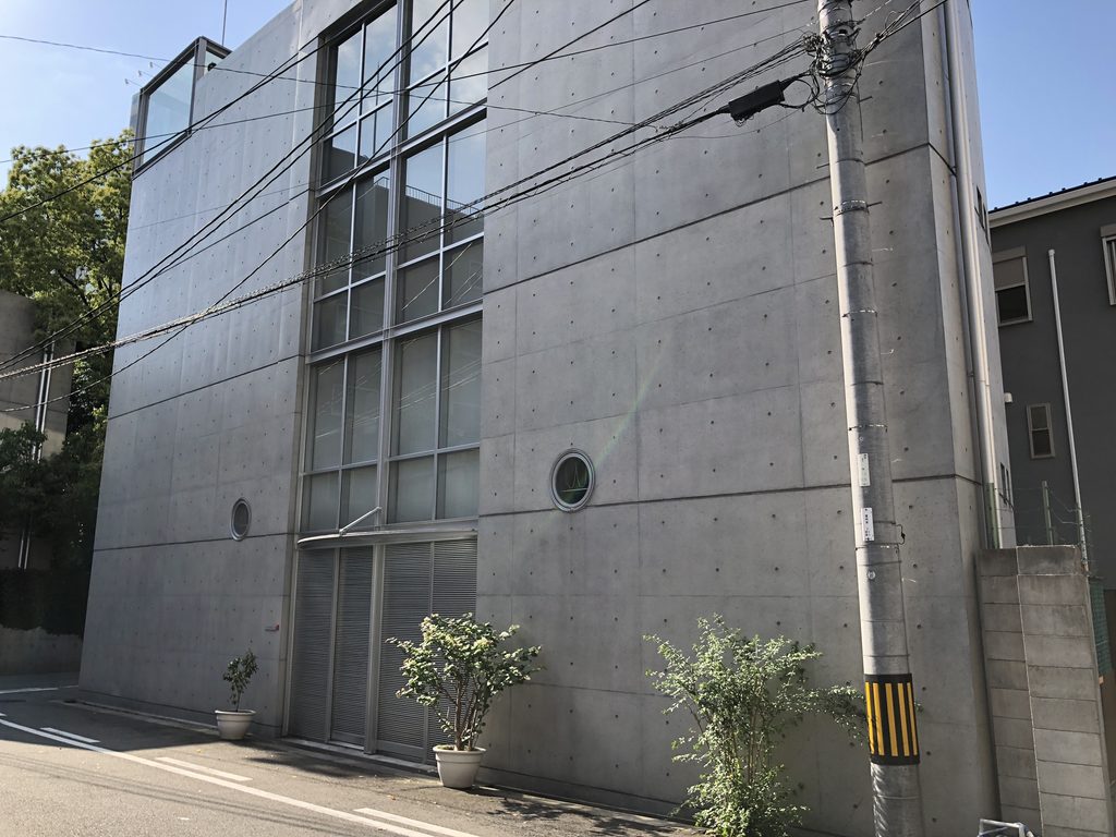 複数階を縦に貫くガラスと打放しコンクリートの壁 / Vertical glazing extending across several floors of the concrete elevation