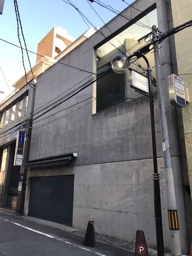 斜めから見たBIGI 2ndのコンクリート壁と上部開口 / Angled view of the concrete facade and upper opening of BIGI 2nd