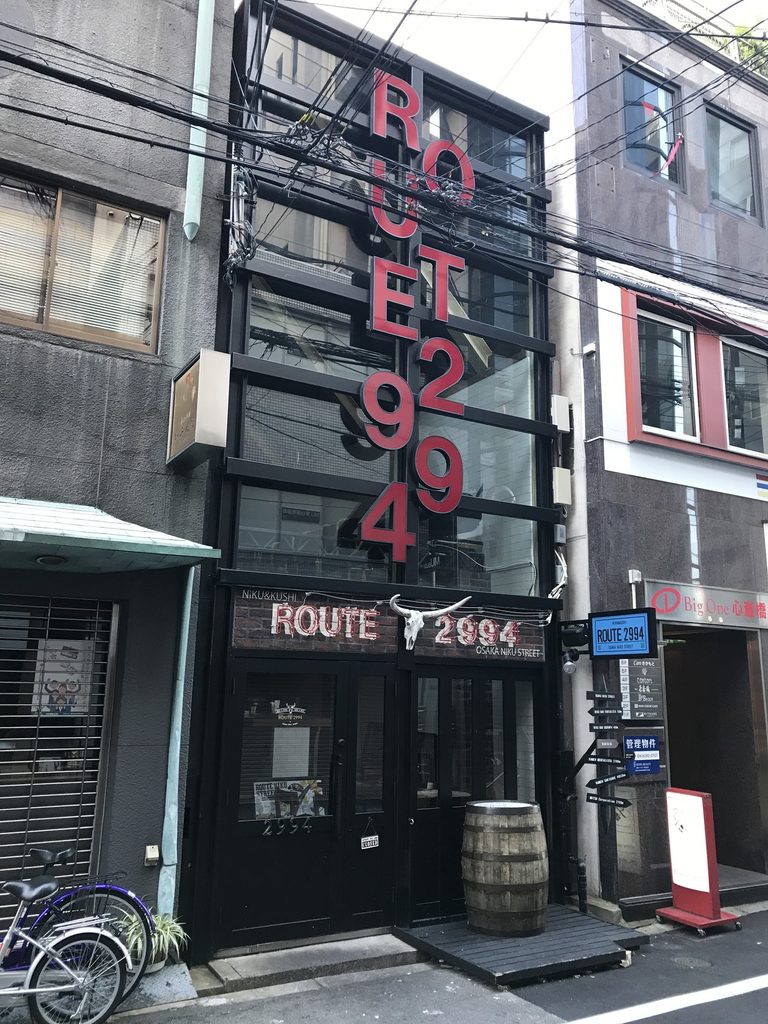 赤いサイン越しに鉄骨とガラスの構成が残るBIGI 3rd / Steel and glass framework of BIGI 3rd visible behind later red signage