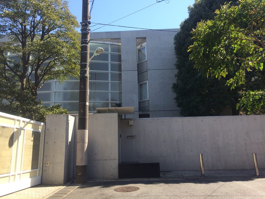 正面から見たBIGI ATELIERの大きな曲面ガラスとコンクリートフレーム / Frontal view of the large curved glazing and concrete frame of BIGI ATELIER