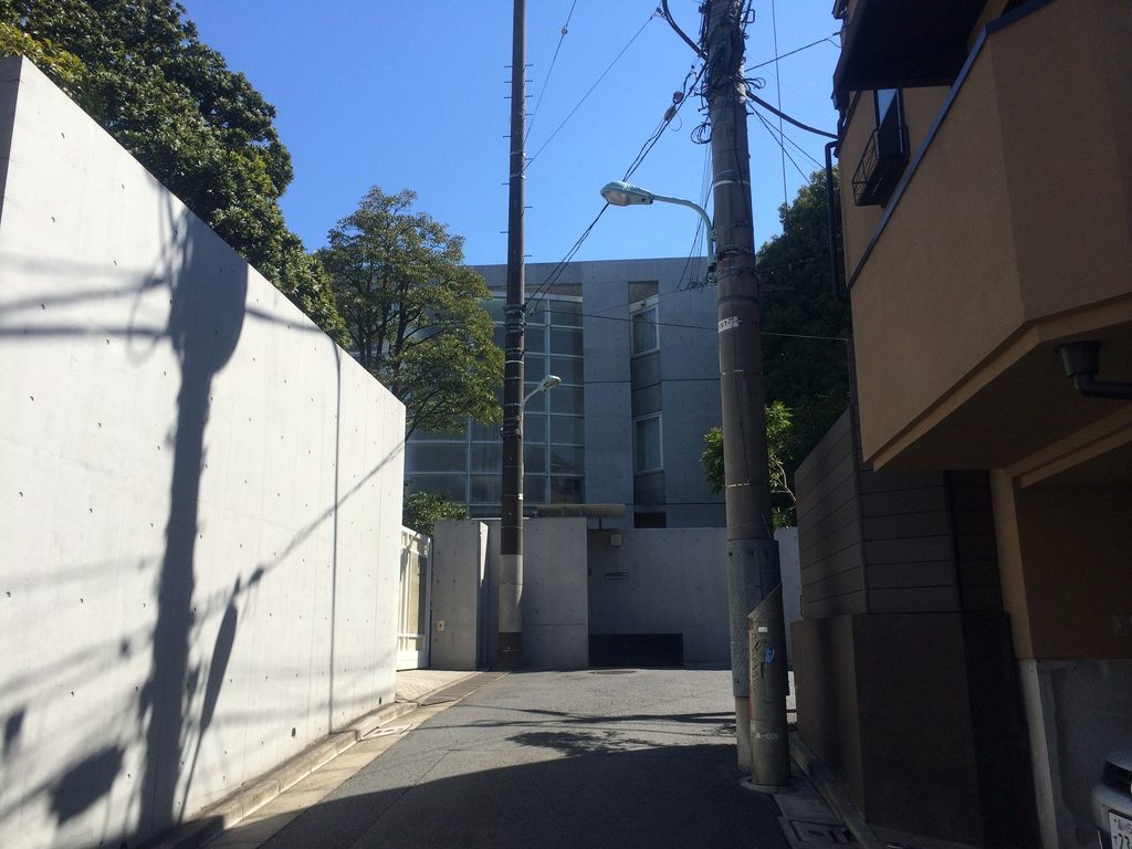 渋谷の細い街路から見たBIGI ATELIERと道路沿いのコンクリート壁 / BIGI ATELIER and its street-side concrete wall seen from a narrow street in Shibuya