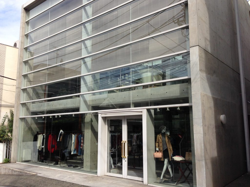 ガラス面と打放しコンクリート壁の関係が見えるCOCUEの外観 / Exterior of COCUE showing the relationship between its glazed facade and exposed-concrete wall