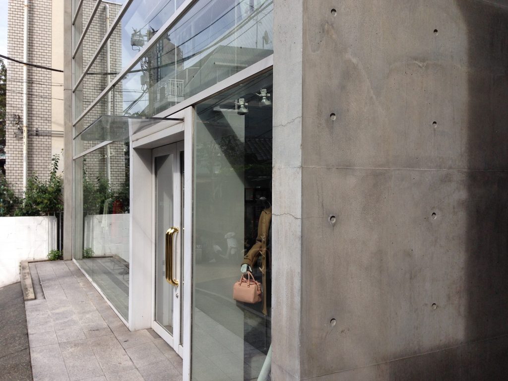 COCUE入口周辺のガラス、白い扉枠、打放しコンクリートのディテール / Detail of glazing, white entrance frame and exposed concrete at COCUE