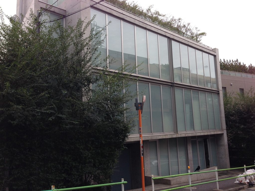 樹木越しに見るCUE NISHIAZABUの大きなガラス立面 / Large glazed facade of CUE NISHIAZABU seen through roadside trees