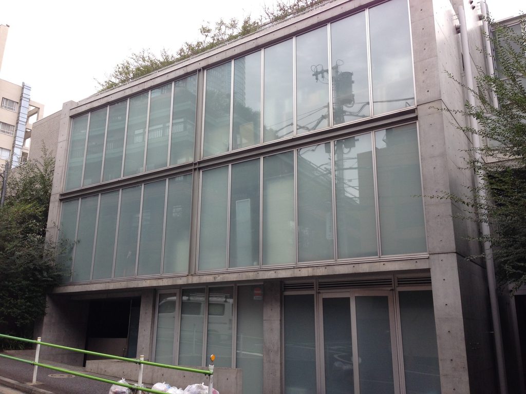 打放しコンクリートに囲まれたCUE NISHIAZABUのガラス立面 / Glazed facade of CUE NISHIAZABU framed by exposed concrete