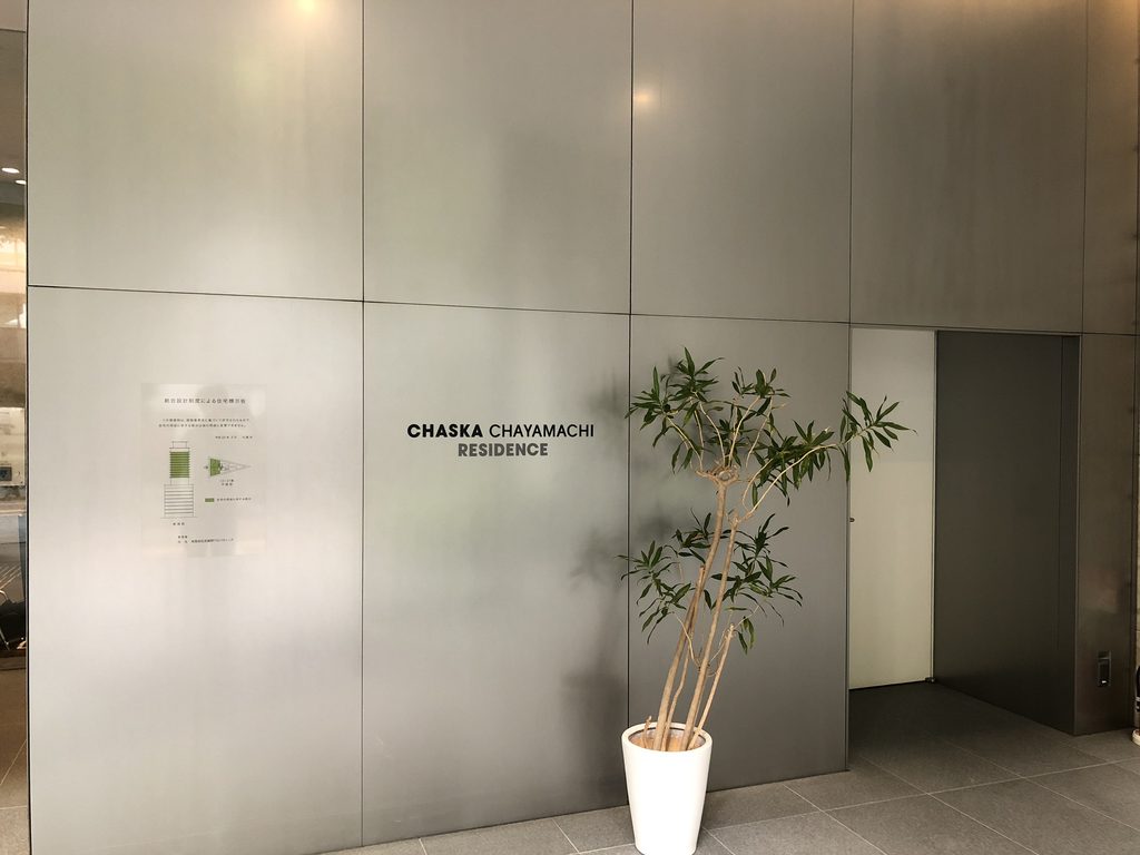 金属パネルの壁に設けられた住宅入口 / Residential entrance set into a metal-paneled wall