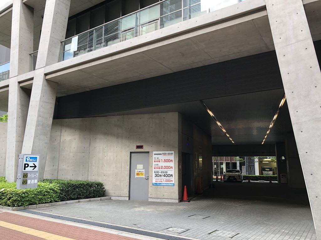 V字柱と張り出した床の下を抜ける車路 / Vehicle passage beneath the V-shaped columns and projecting floors