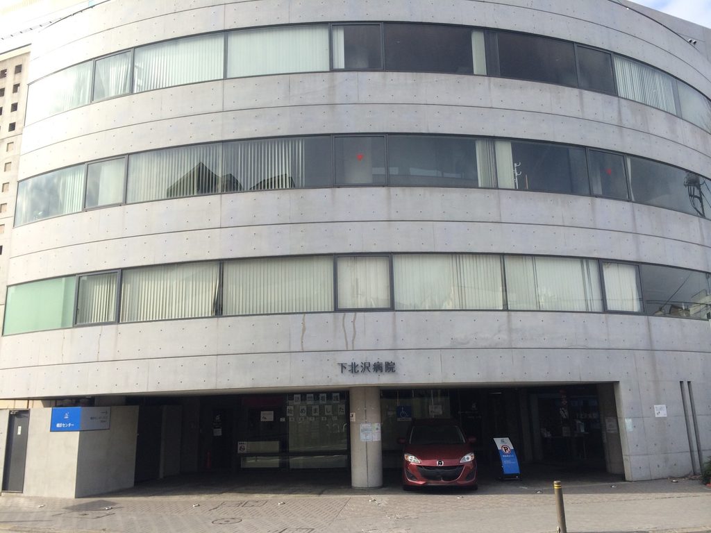 道路に沿って弧を描く下北沢病院正面と水平連続窓 / Curved front elevation and continuous horizontal windows of Shimokitazawa Hospital