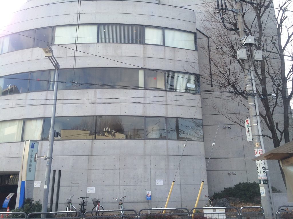 コンクリートの帯と水平窓が重なる旧福原病院の正面立面 / Front elevation of the former Fukuhara Hospital with layered concrete bands and horizontal windows