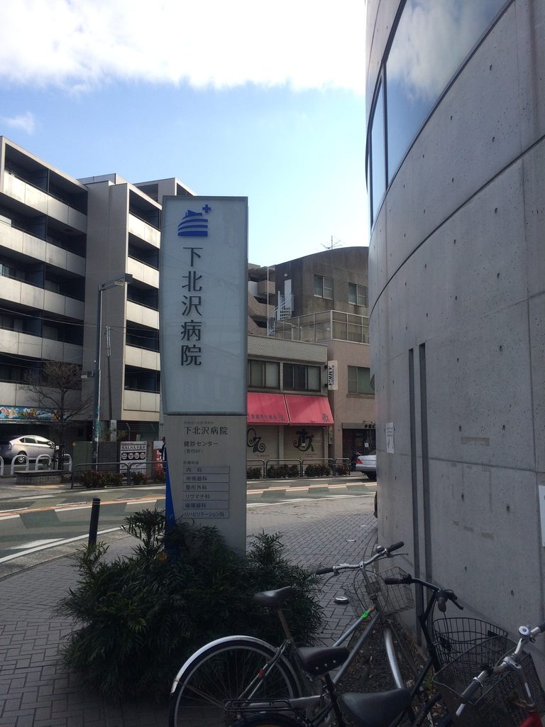 下北沢病院の案内サインと旧福原病院のコンクリート外壁 / Shimokitazawa Hospital sign beside the concrete exterior of the former Fukuhara Hospital
