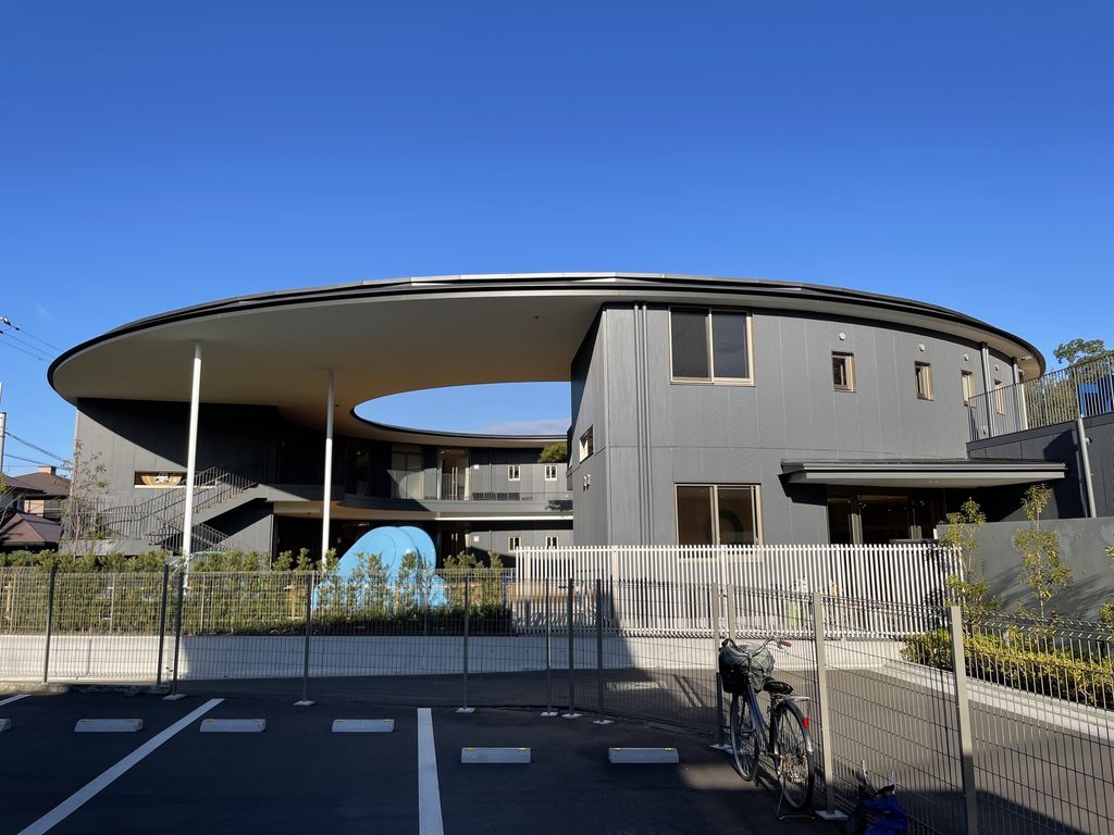 円形屋根の下に園舎と中庭が見える五風会の道路側外観 / Street view of Gofukai showing the school and courtyard beneath the circular roof