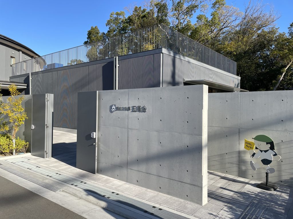 認定こども園五風会の名称を掲げた打放しコンクリートの入口壁 / Exposed-concrete entrance wall bearing the name of Gofukai