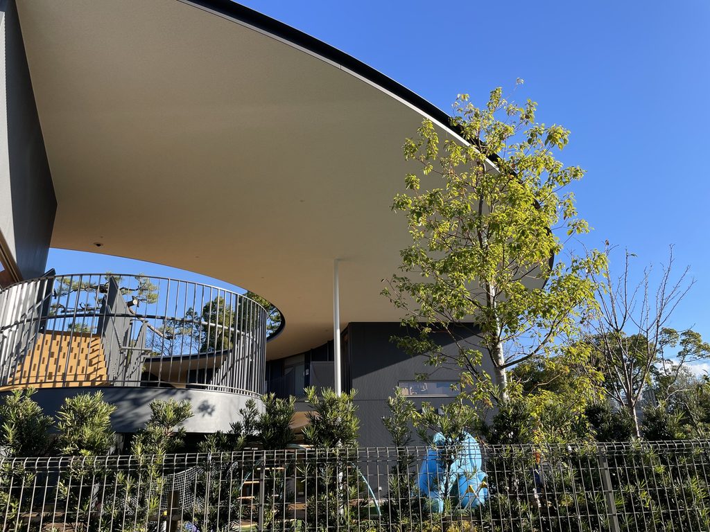 植栽越しに円形屋根の中央開口を望む五風会 / Central roof opening of Gofukai seen beyond the planting
