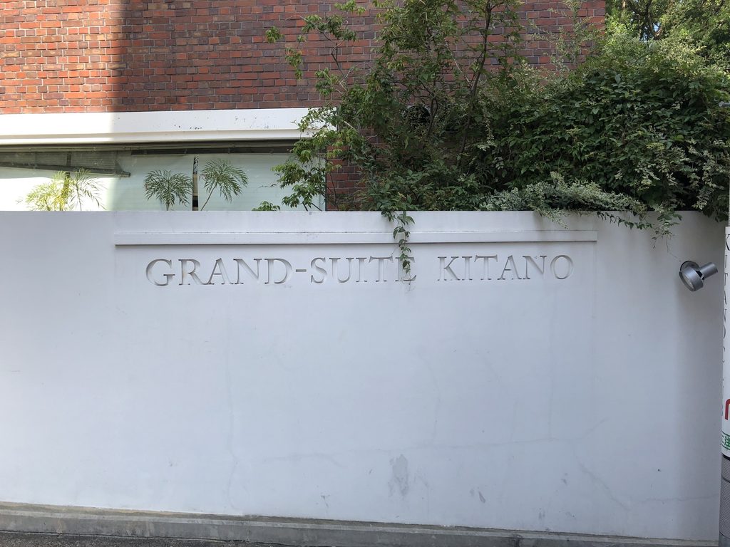 白い外壁に刻まれたGRAND-SUITE KITANOの建物名 / GRAND-SUITE KITANO name inscribed on the white boundary wall