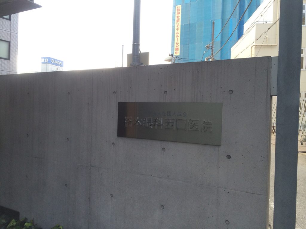 打放しコンクリート壁に設置された橋本眼科西口医院の銘板 / Hashimoto Eye Clinic sign mounted on an exposed-concrete wall