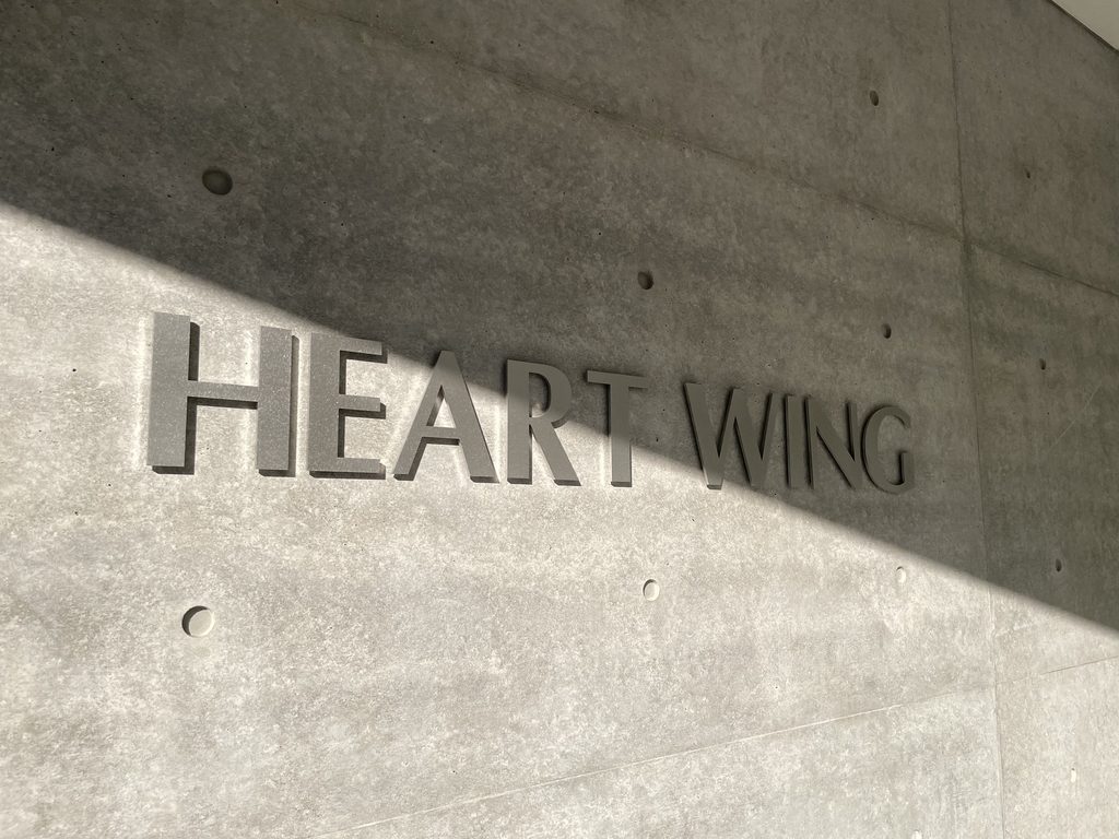 打放しコンクリート壁に記されたHEART WINGのロゴ / HEART WING logo on an exposed-concrete wall
