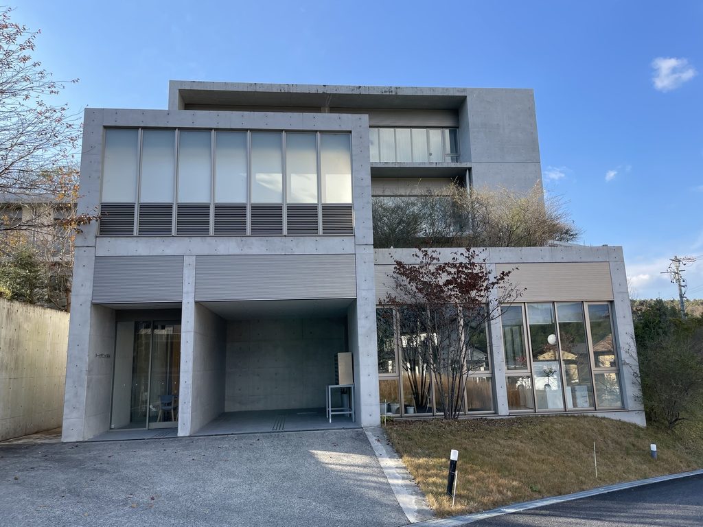 コンクリートフレームの奥に設けられたハートウィングの入口 / HEART WING entrance recessed behind a concrete frame
