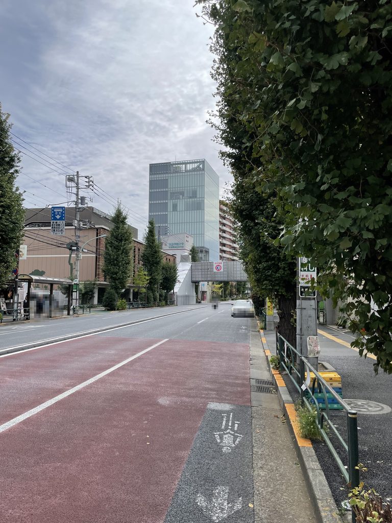 通りの並木の先に見える東大前 HiRAKU GATE / Todai-mae HiRAKU GATE seen beyond the street trees