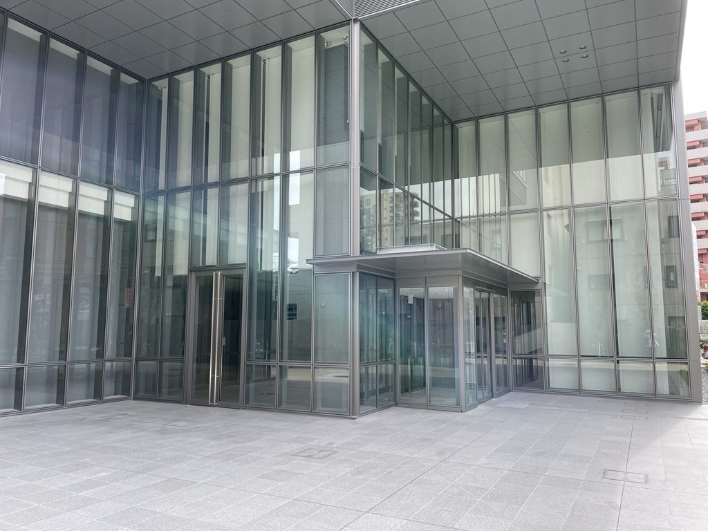 四層分のピロティの奥に置かれたガラスのエントランス / Glass entrance set within the four-story pilotis