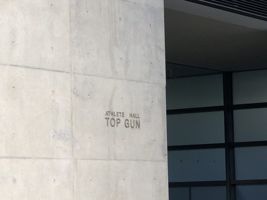 コンクリート壁に刻まれたATHLETE HALL TOP GUNの文字 / ATHLETE HALL TOP GUN lettering on a concrete wall