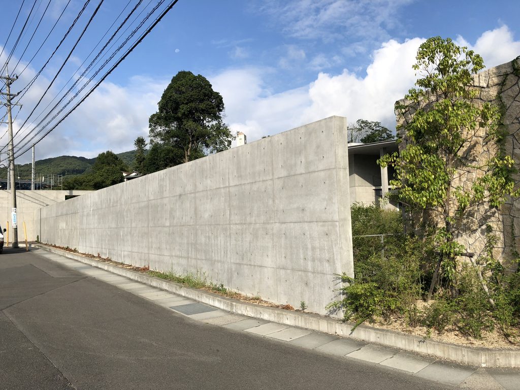 道路に沿って続くPHILOSOPHIAの外周壁 / Perimeter concrete wall of PHILOSOPHIA along the road