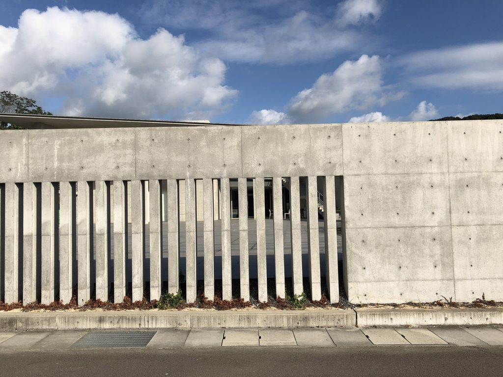細い縦スリットが連続するコンクリート壁 / Concrete wall with a continuous row of narrow vertical slits