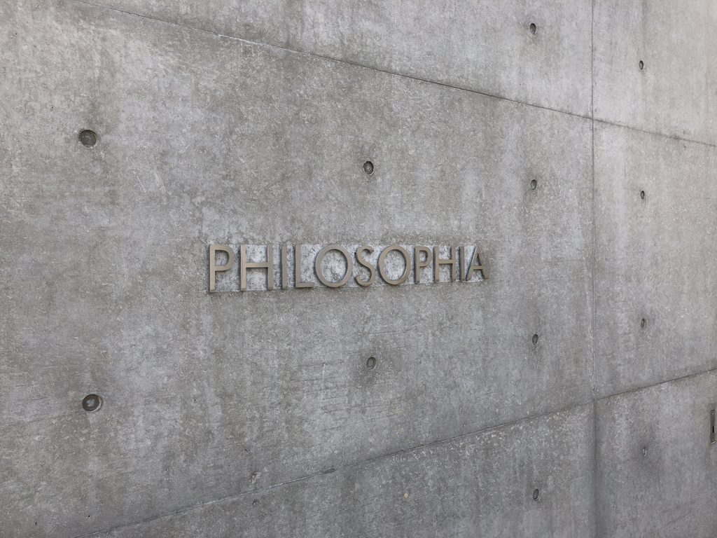 打放し壁に取り付けられたPHILOSOPHIAの文字 / PHILOSOPHIA lettering mounted on an exposed-concrete wall