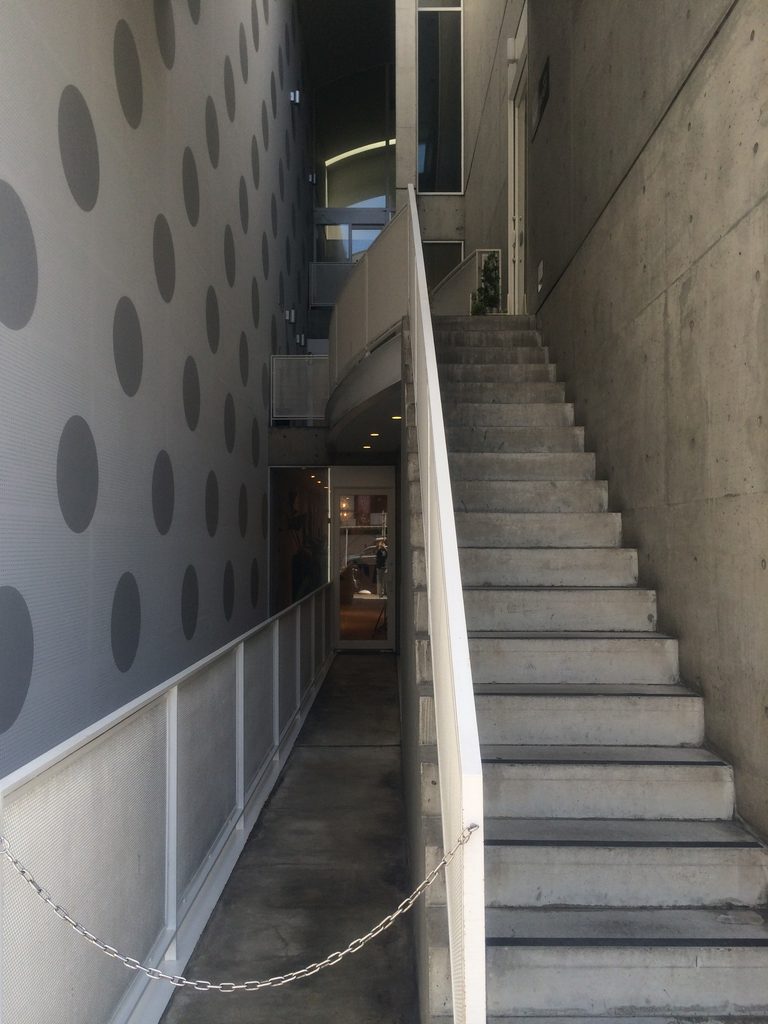 細い吹抜けの中を上階へ続くJ ROOMのコンクリート階段 / Concrete stair climbing through the narrow vertical void of J ROOM