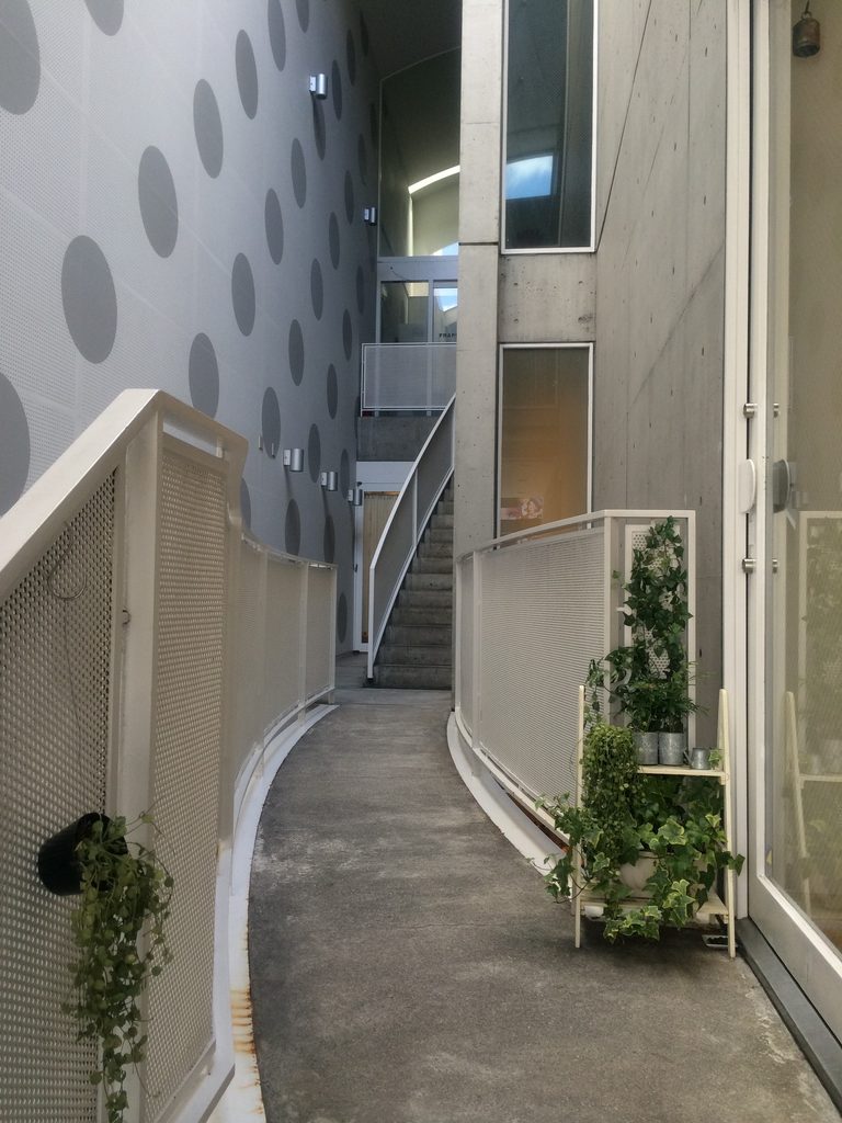 曲面の壁に沿って伸びるJ ROOMの細い通路 / Narrow passage following a curved wall inside J ROOM