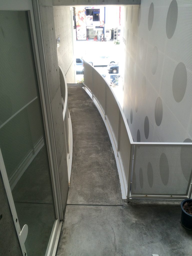 曲線を描きながら吹抜けに沿うJ ROOMの通路 / Curving passage running alongside the vertical void of J ROOM