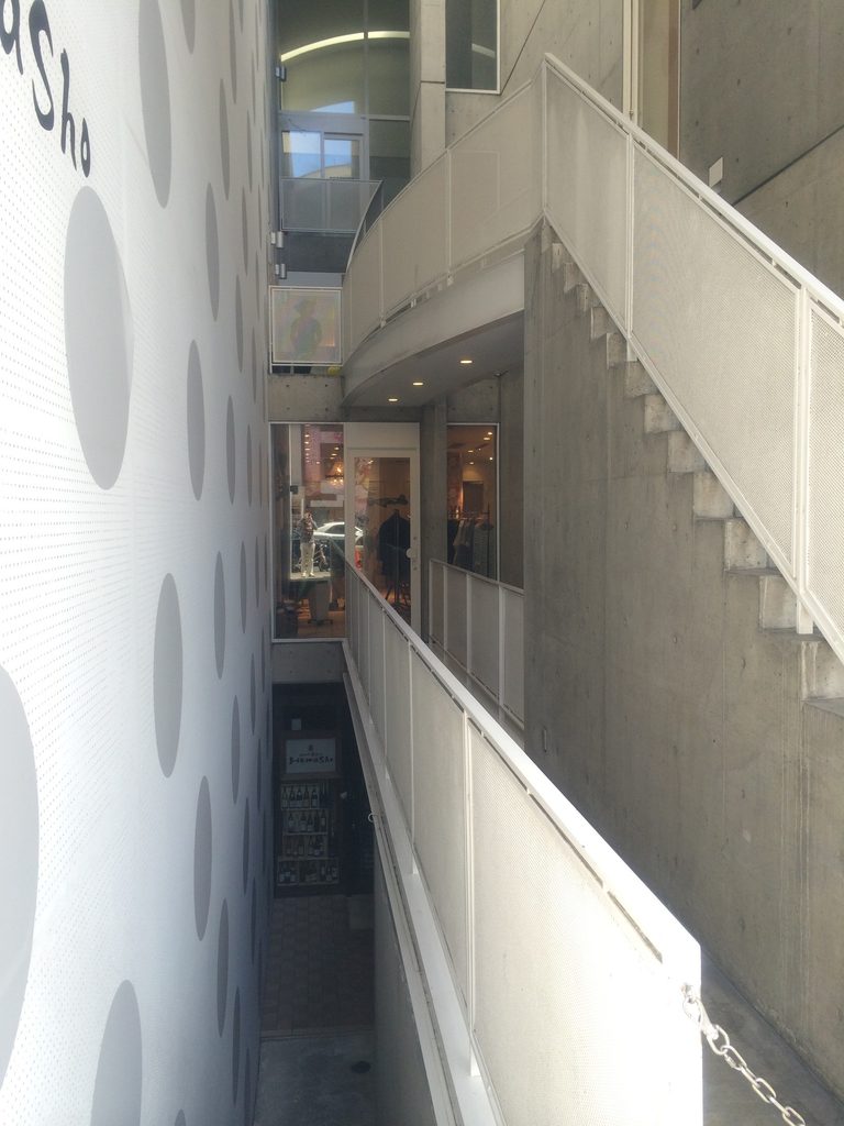 上階通路から見下ろすJ ROOMの階段と吹抜け / Stairs and vertical void of J ROOM viewed from an upper-level passage