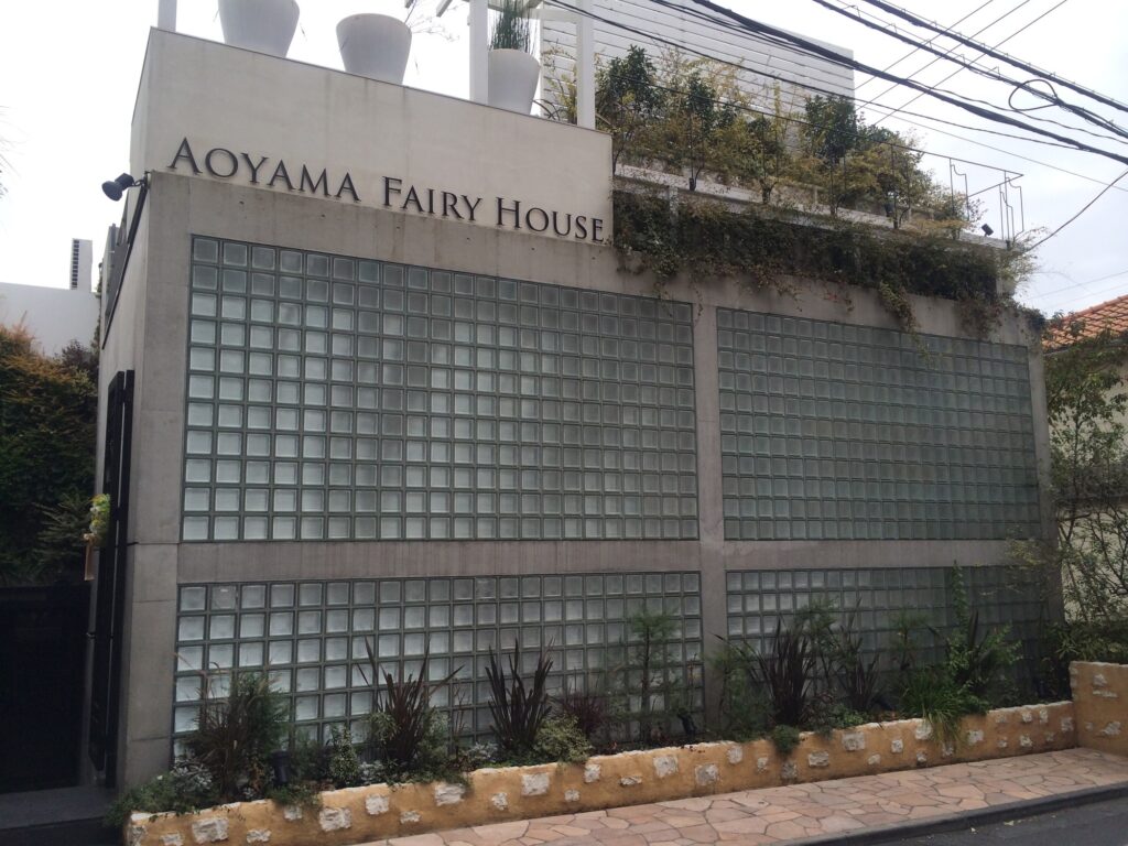 旧 神宮前のアトリエ正面に広がるガラスブロック壁と打放しコンクリートのフレーム / Glass-block facade and exposed-concrete frame of the Former Jingumae Atelier