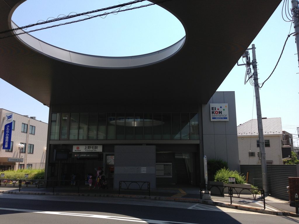 大屋根の下に正面口とガラス張りの駅舎が収まる上野毛駅 / Main entrance and glazed station building beneath the large roof at Kaminoge Station