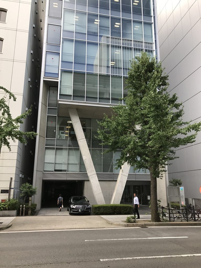 街路から見たMKD10大阪のガラス外壁とV字形のコンクリート柱 / Glazed facade and V-shaped concrete columns of MKD10 Osaka viewed from the street
