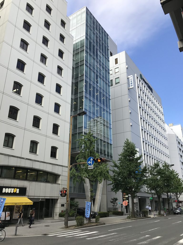 道路の反対側から見るMKD10大阪の縦長のガラスファサード / Tall glazed facade of MKD10 Osaka viewed from across the road