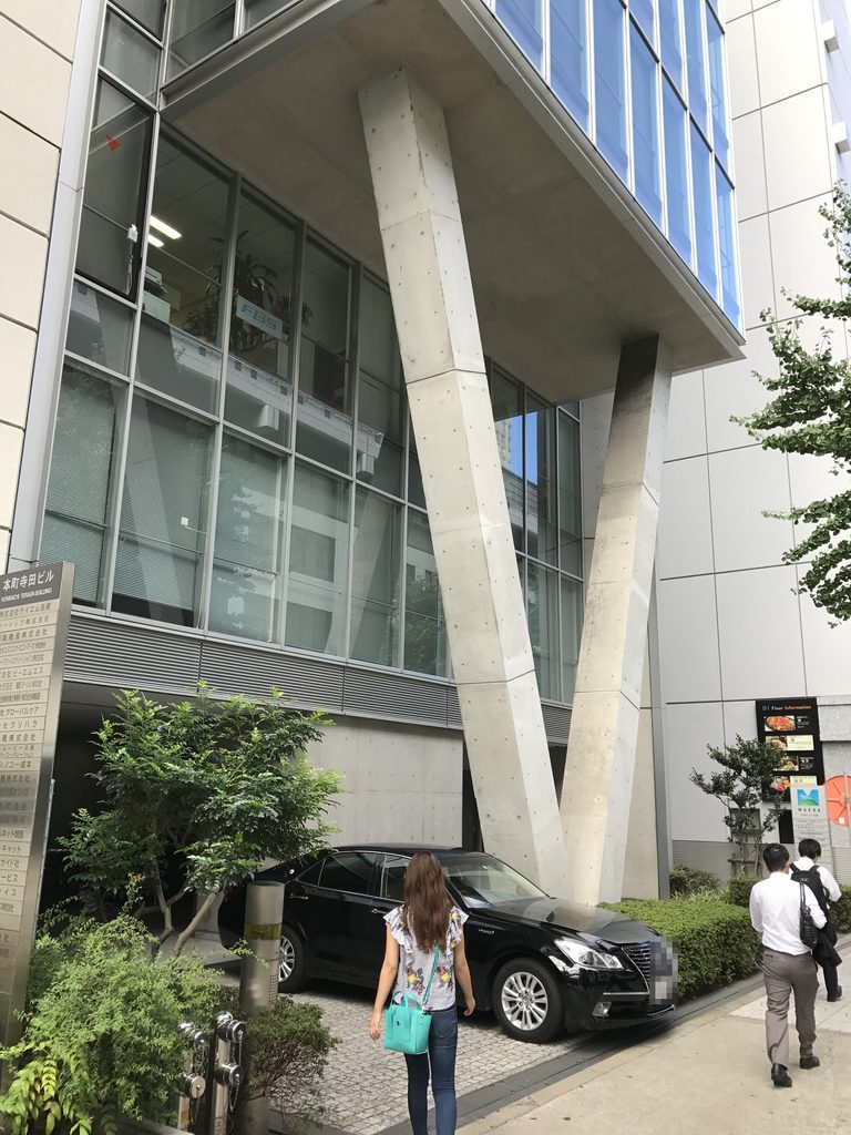 V字柱とガラス張りの上階を見上げるMKD10大阪の外観 / Upward view of the V-shaped columns and glazed upper floors of MKD10 Osaka