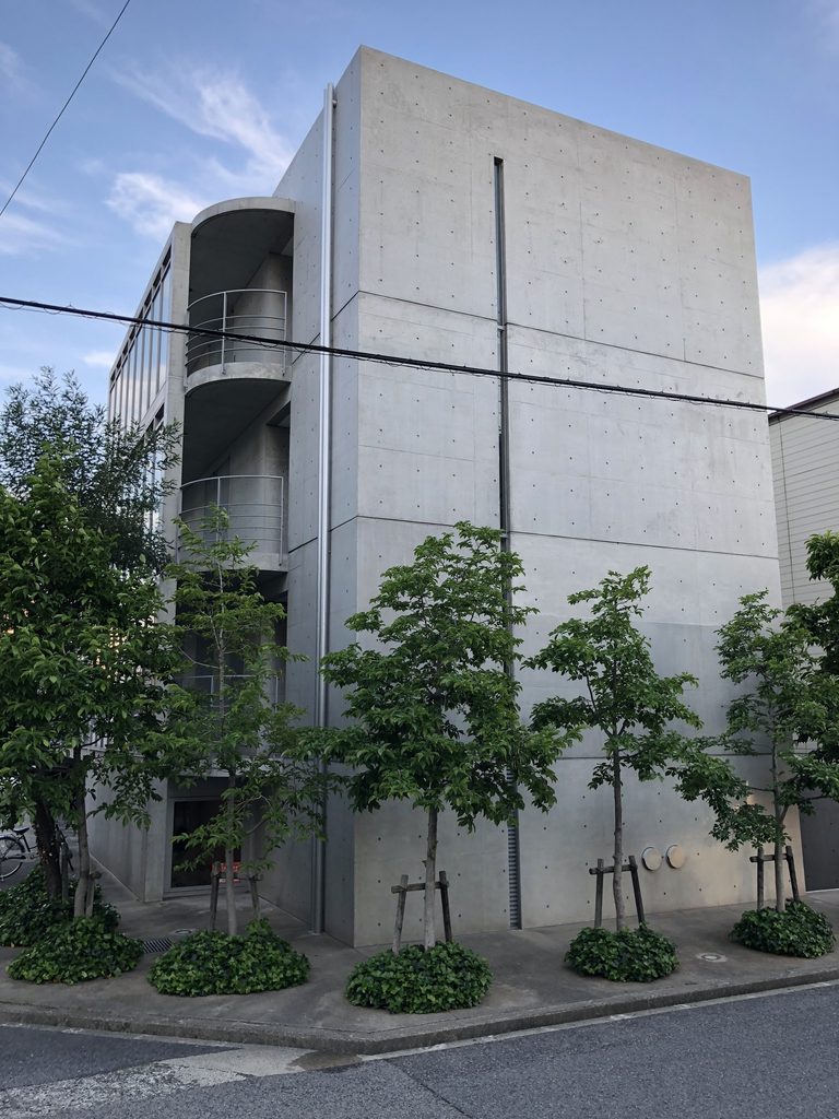 街角から見たマグノリアの大きなコンクリート壁と曲面バルコニー / Concrete end wall and curved balconies of MAGNOLIA viewed from the street corner