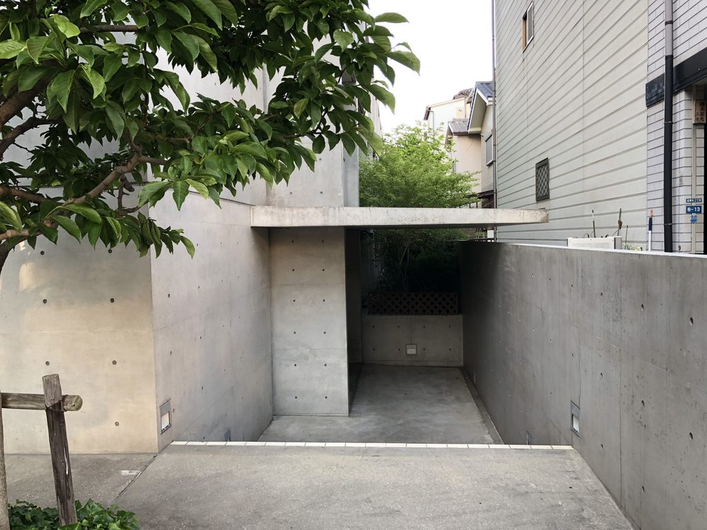 コンクリート壁の間を奥へ導くマグノリアのエントランス / Recessed entrance to MAGNOLIA framed by exposed-concrete walls