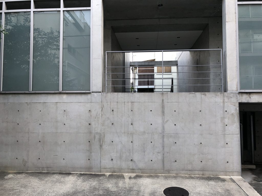 打放しコンクリート壁に四角い開口が設けられたマグノリアの外壁 / Square opening cut into the exposed-concrete wall of MAGNOLIA