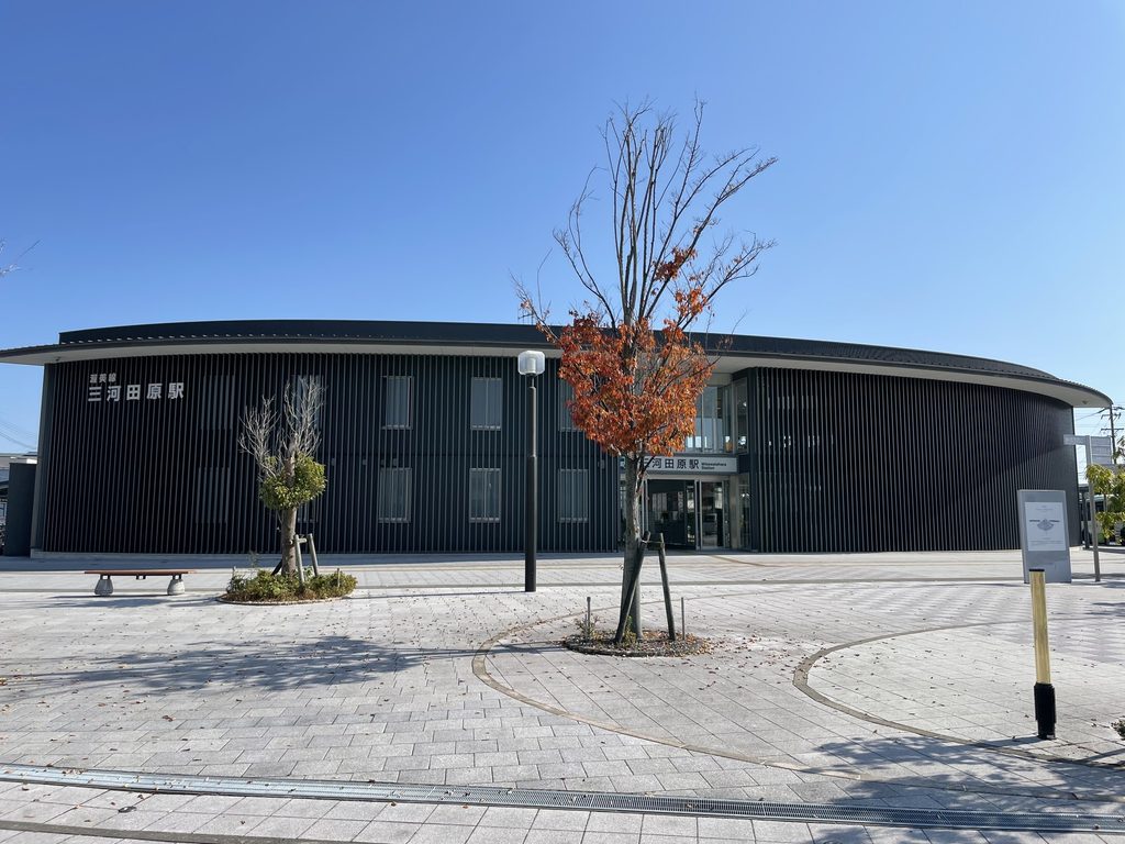 駅前広場から見た三河田原駅の曲線を描く駅舎全景 / Overall view of Mikawa-Tahara Station and its sweeping curved form from the station plaza