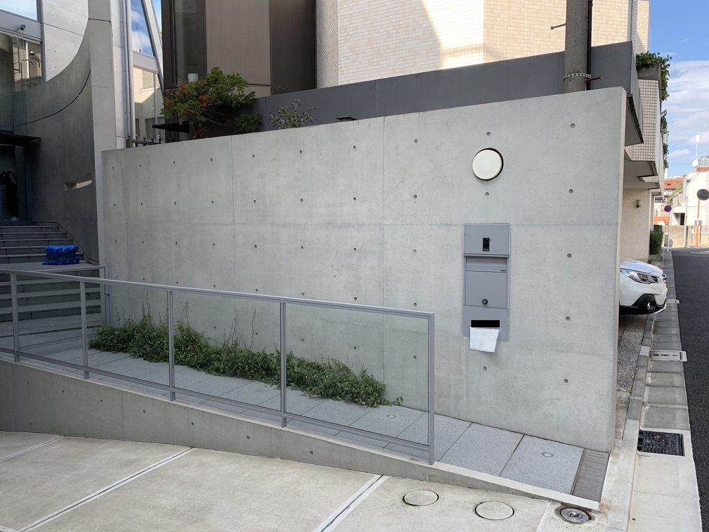 元麻布の住宅の街路沿いに設けられた低いコンクリート壁とスロープ / Low concrete street wall and sloping approach at House in Motoazabu