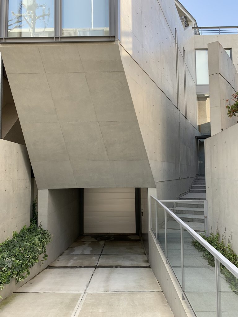 ガラス面と斜めのコンクリート壁が重なる元麻布の住宅の外観 / Exterior of House in Motoazabu with overlapping glass and angled concrete surfaces