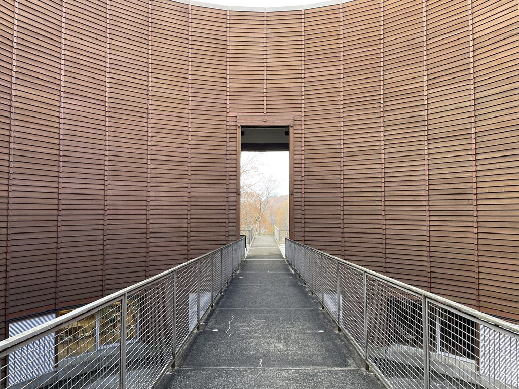 円形の木壁を貫く木の殿堂の直線通路 / Axial passage cutting through the circular timber wall of the Museum of Wood