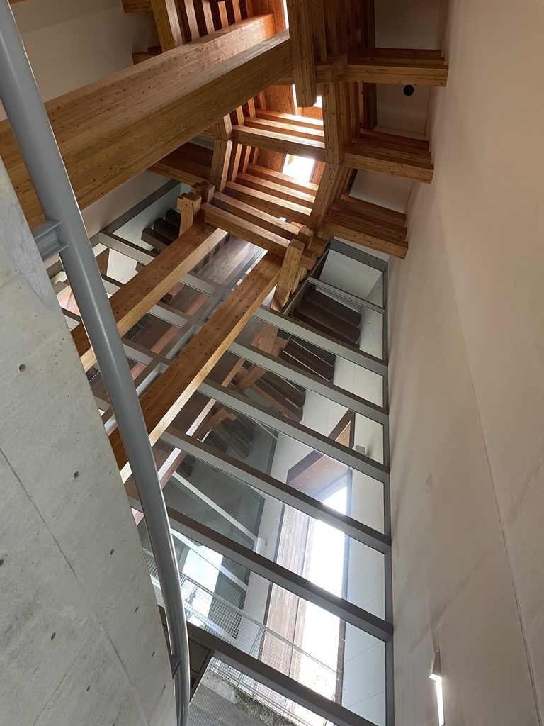 天窓へ伸びる木の殿堂の木構造とガラス面 / Timber structure rising toward skylights inside the Museum of Wood