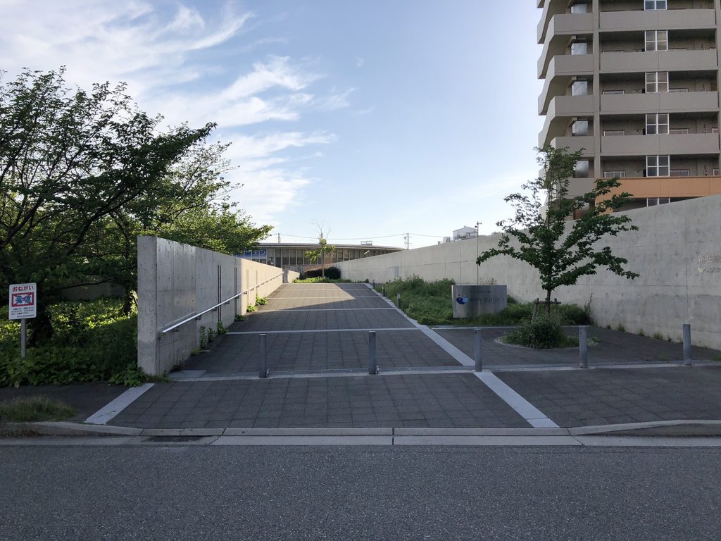 道路から新在家南公園へまっすぐ延びるアプローチとコンクリート壁 / Straight approach from the street into Shinzaike Minami Park between concrete walls