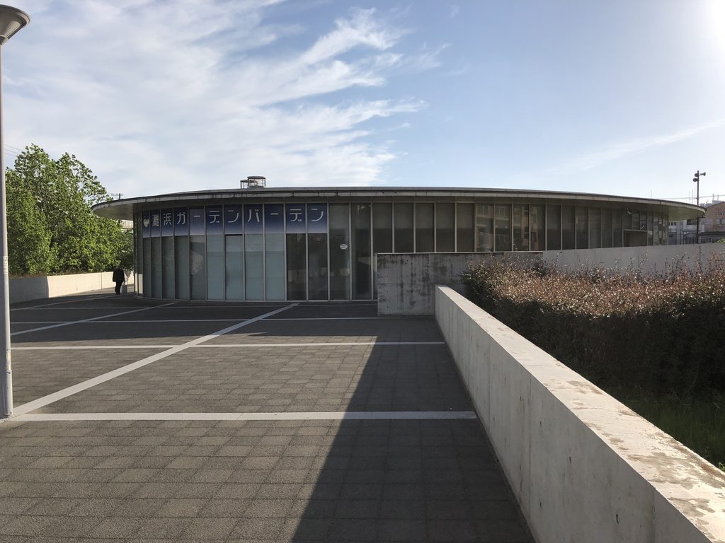 広場に面して緩やかに湾曲する灘浜ガーデンバーデンのガラスファサード / Gently curving glazed facade of Nadahama Garden Baden facing the plaza