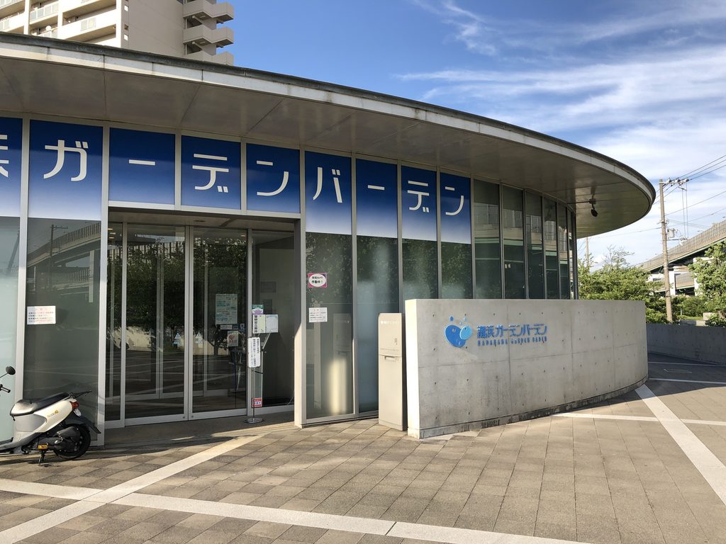 芝生越しに見る灘浜ガーデンバーデンの低く湾曲したガラスファサード / Low curved glazed facade of Nadahama Garden Baden viewed across the lawn