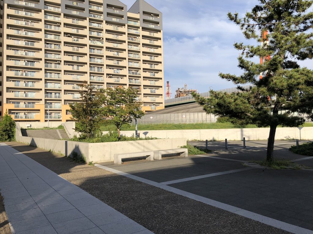 集合住宅を背景にした新在家南公園の広場と段差のあるコンクリート壁 / Plaza and stepped concrete walls of Shinzaike Minami Park with apartment housing beyond