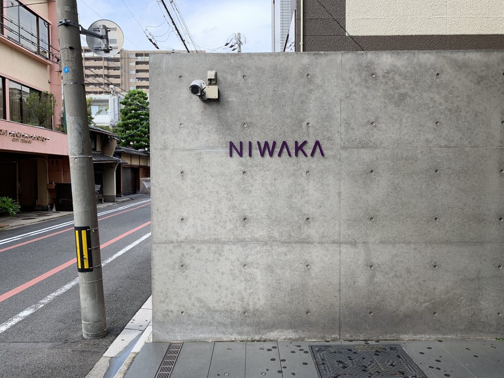 NIWAKAの文字を取り付けた俄ビルの打放しコンクリート壁 / Exposed-concrete wall of the NIWAKA Building carrying the NIWAKA lettering