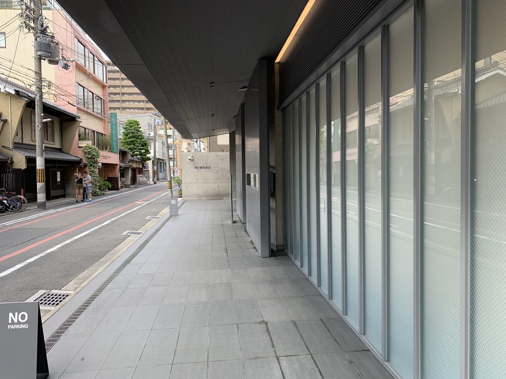 深い庇の下を通る俄ビル前の歩道 / Sidewalk passing beneath the deep eave of the NIWAKA Building